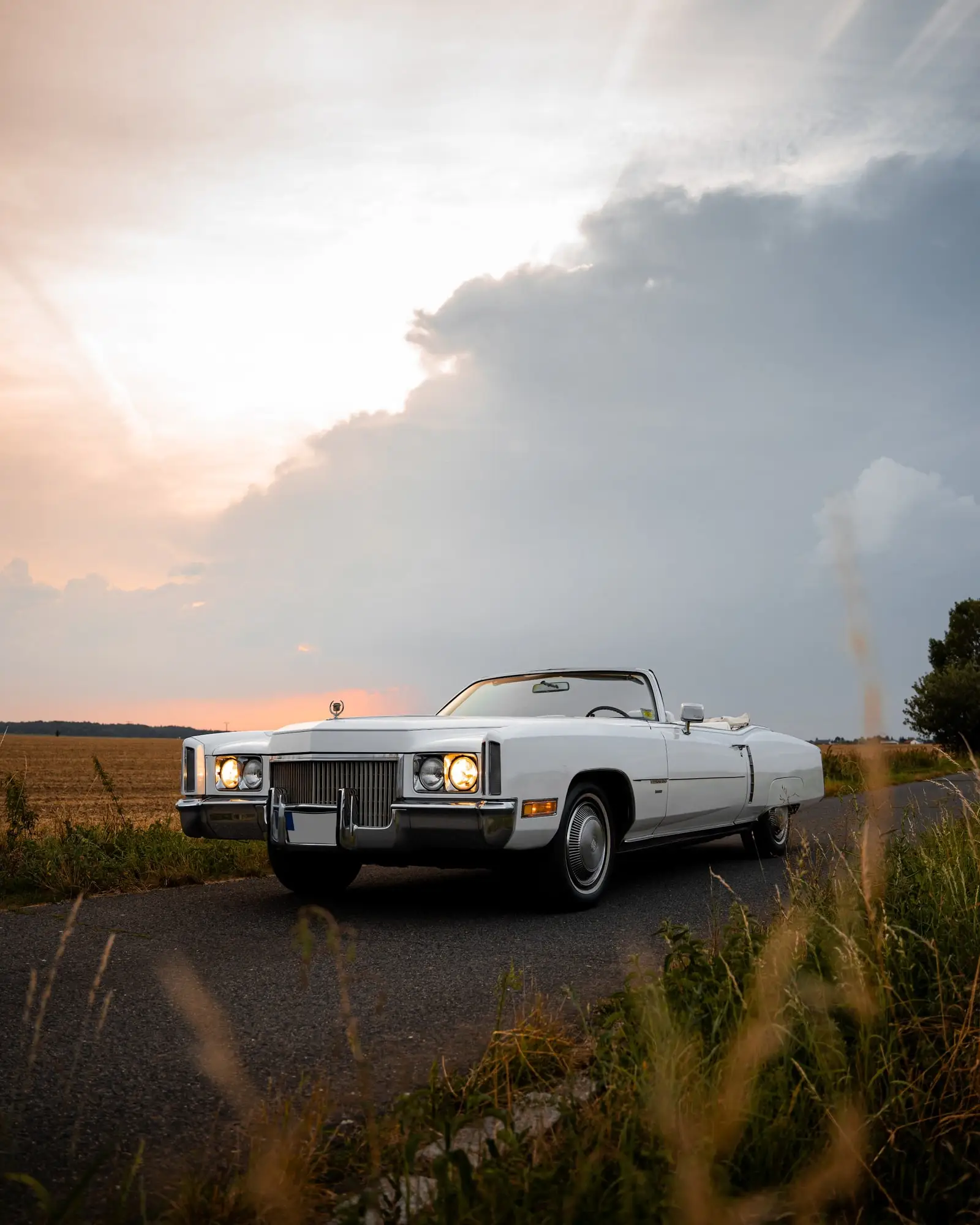 Bílý Cadillac Eldorado zepředu při západu slunce